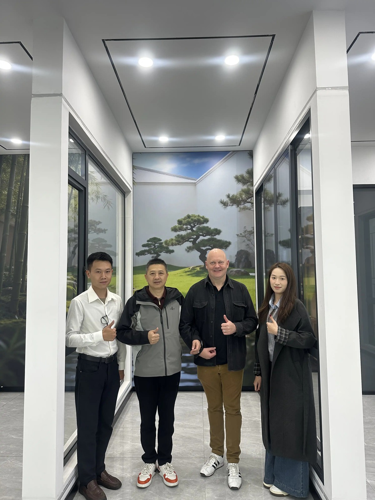 Four people posing together among window displays during a customer visit to Guantian