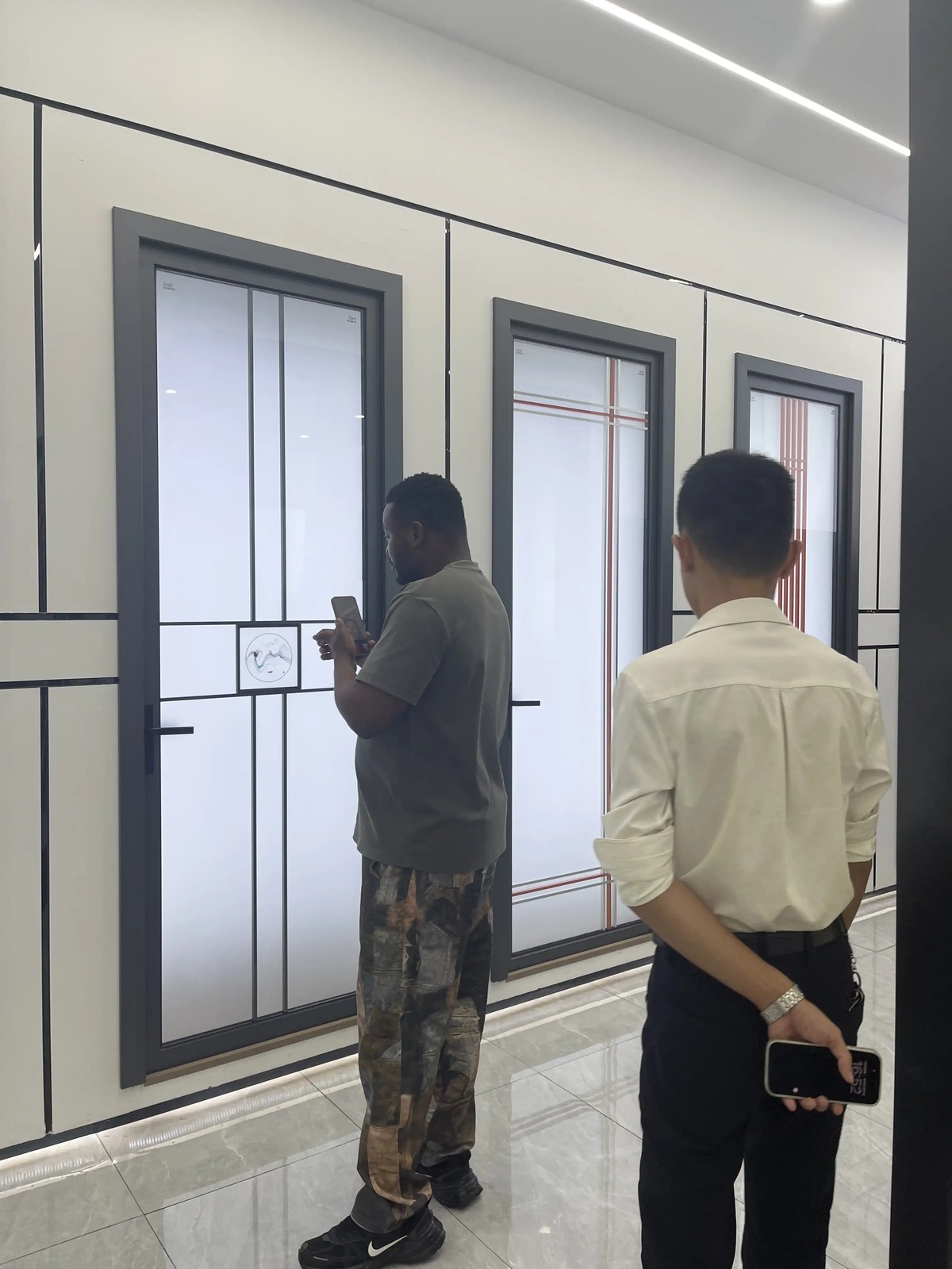 A customer reviewing a window display with a Guantian representative nearby