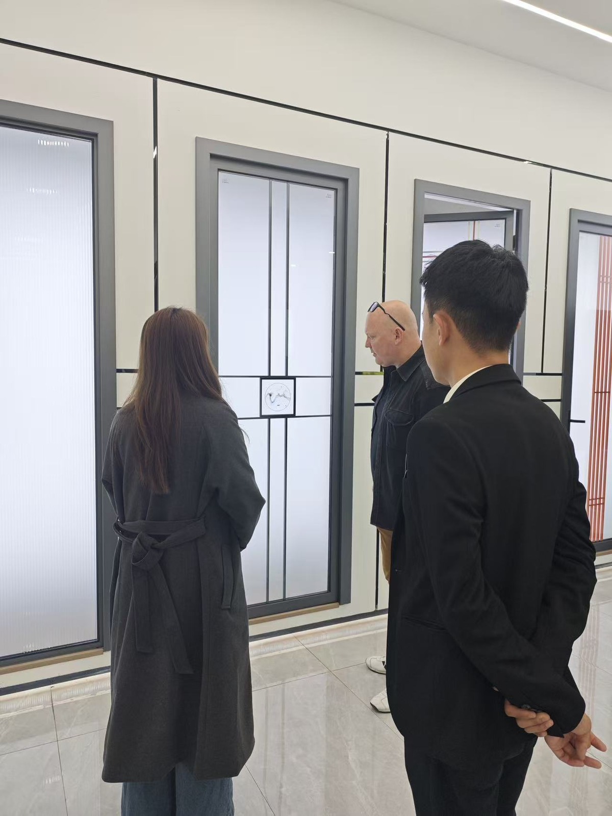 Visitors discussing an assembled window display in the Guantian showroom