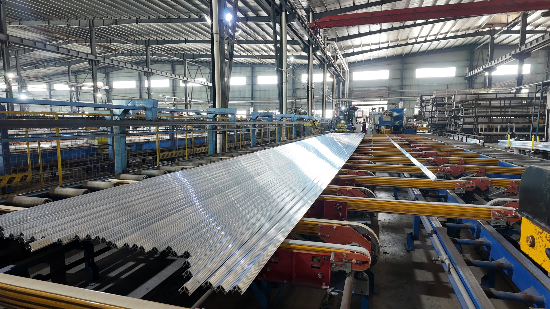 Long aluminum profiles resting on the production rollers